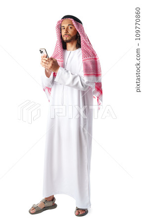 Young Arab man in traditional dress thobe using smartphone at white background 109770860