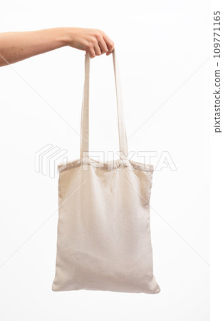 Hand holding tote bag mock up, isolated on white background. Organic natural shopper 109771165