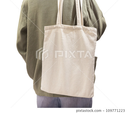 Natural eco tote bag mockup on shoulder. Woman back with shopper isolated on white Natural eco tote bag mockup on shoulder. Woman back with shopper isolated on white 109771223