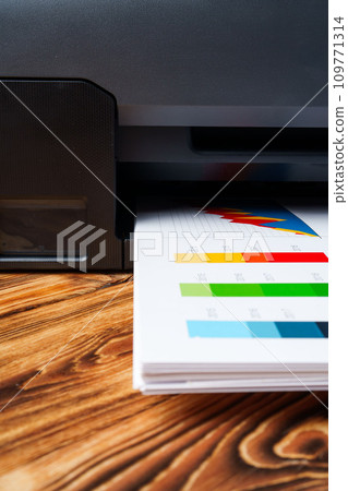 Modern laser printer with paper on wooden background Modern laser printer with paper on wooden background 109771314