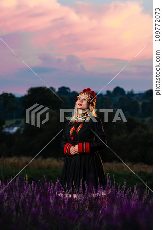 The girl is wearing a chelsea headdress and a black dress decorated with red embroidery The girl is wearing a chelsea headdress and a black dress decorated with red embroidery 109772073