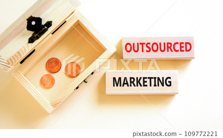 Outsourced marketing symbol. Concept words Outsourced marketing on beautiful wooden blocks. Beautiful white table white background. Wooden chest coins. Business Outsourced marketing concept Copy space Outsourced marketing symbol. Concept words Outsourced marketing on beautiful wooden blocks. Beautiful white table white background. Wooden chest coins. Business Outsourced marketing concept Copy space 109772221