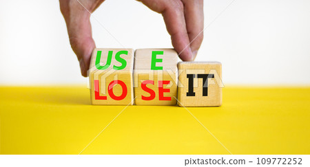You use or lose it symbol. Concept word Use It or lose it on wooden cubes. Beautiful yellow table white background. Businessman hand. Business and you use or lose it concept. Copy space. 109772252