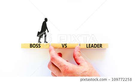 Boss vs leader symbol. Concept words Boss vs versus leader on wooden block. Beautiful white table white background. Businessman hand. Business motivational boss vs leader concept. Copy space. 109772258