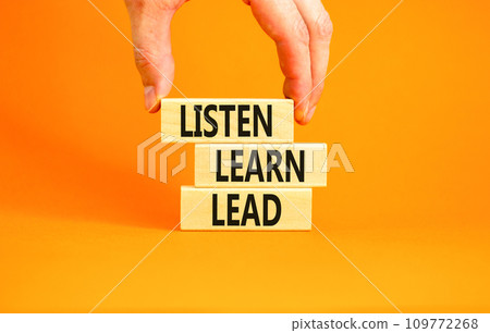 Listen learn lead symbol. Concept word Listen Learn Lead on beautiful wooden block. Businessman hand. Beautiful orange table orange background. Business education listen learn lead concept. Copy space 109772268