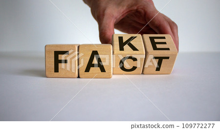 Business and design concept. Man hand flips wooden cubes with words 'FACT FAKE' concept on beautiful white background, copy space. 109772277