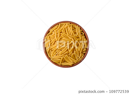 Raw whole grain wheat pasta with salt and spices in a ceramic plate Raw whole grain wheat pasta with salt and spices in a ceramic plate 109772539