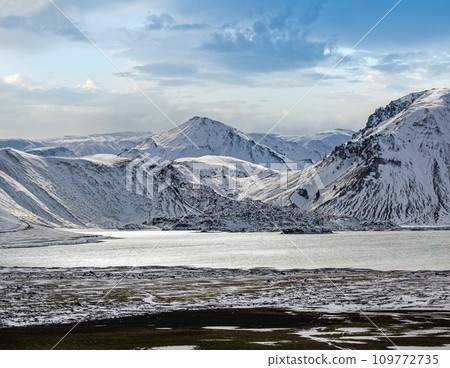 Season changing in southern Highlands of Iceland. Colorful Landmannalaugar mountains under snow cover in autumn. Frostastadavatn lake at the foot of the mountains. 109772735