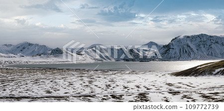 Season change in the Icelandic highlands. Colorful Landmannalaugar mountains under snow cover in autumn. Frostastadavatn lake at the foot of the mountains. Season change in the Icelandic highlands. Colorful Landmannalaugar mountains under snow cover in autumn. Frostastadavatn lake at the foot of the mountains. 109772739
