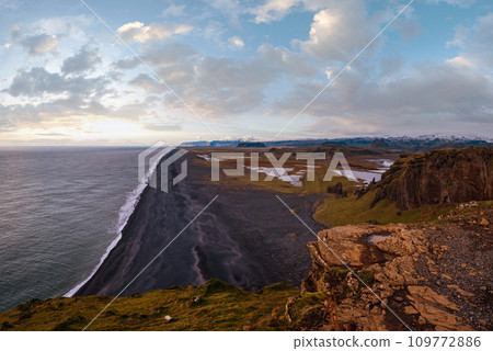 Picturesque autumn evening view to endless ocean black volcanic sand beach from Dyrholaey Cape Viewpoint, Vik, South Iceland. Picturesque autumn evening view to endless ocean black volcanic sand beach from Dyrholaey Cape Viewpoint, Vik, South Iceland. 109772886