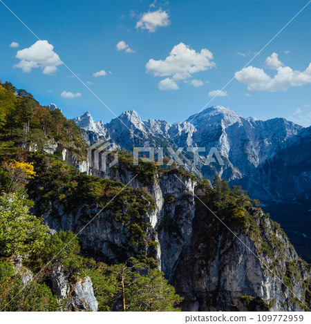 Sunny colorful autumn alpine scene. Peaceful rocky mountain view from hiking path near Almsee lake, Upper Austria. 109772959