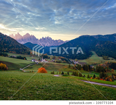 Autumn daybreak Santa Magdalena famous Italy Dolomites village view in front of the Geisler or Odle Dolomites mountain rocks. Picturesque traveling and countryside beauty concept background. Autumn daybreak Santa Magdalena famous Italy Dolomites village view in front of the Geisler or Odle Dolomites mountain rocks. Picturesque traveling and countryside beauty concept background. 109773104