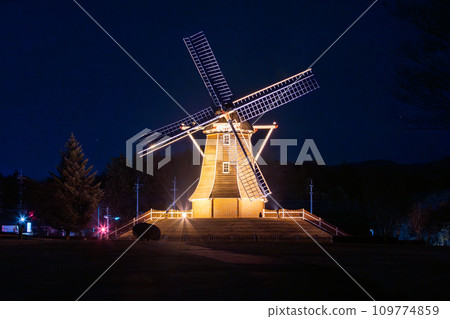 Windmills at the roadside station Green Flower Farm illuminated Windmills at the roadside station Green Flower Farm illuminated 109774859
