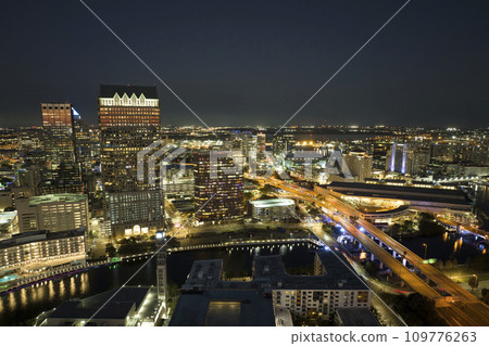 View from above of brightly illuminated high skyscraper buildings and moving traffic in downtown district of Tampa city in Florida, USA. American megapolis with business financial district at night 109776263