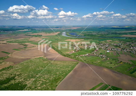 Aerial view of plowed agricultural fields with cultivated fertile soil prepared for planting crops between green woods in spring 109776292