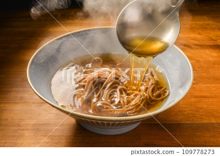 Pour the soup stock over the warm soba noodles 109778273