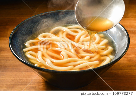 Pour the soup stock over the warm udon noodles Pour the soup stock over the warm udon noodles 109778277