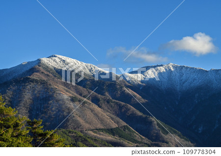A mountain covered with snow near the summit 109778304