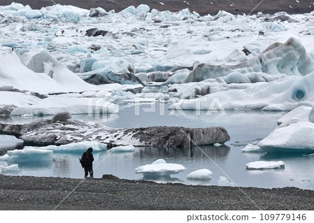 Photographer picking up pieces of icebergs 109779146