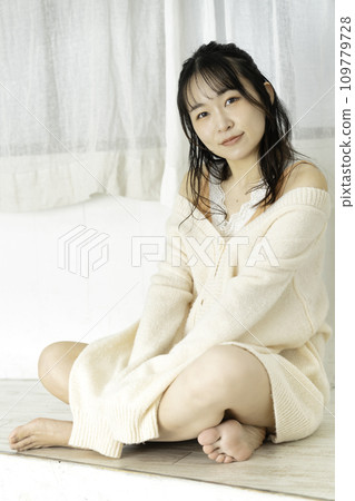 A young woman wearing a feminine white knitwear 109779728