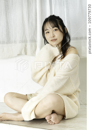 A young woman wearing a feminine white knitwear 109779730