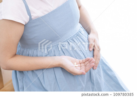 Image of a pregnant woman taking medicine 109780385