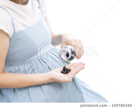 Image of a pregnant woman taking supplements Image of a pregnant woman taking supplements 109780389