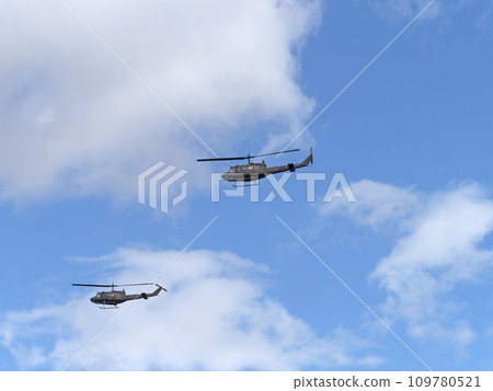 Japan Ground Self-Defense Force UH-1J helicopter flying in the blue sky Japan Ground Self-Defense Force UH-1J helicopter flying in the blue sky 109780521