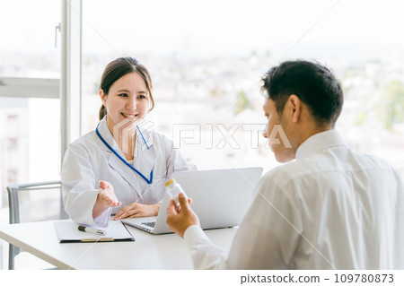 Doctor recommending medicine / Doctor and middle-aged man patient (medication guidance, hair loss treatment, AGA, drugs) 109780873