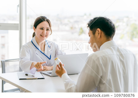 Doctor recommending medicine / Doctor and middle-aged man patient (medication guidance, hair loss treatment, AGA, drugs) 109780876