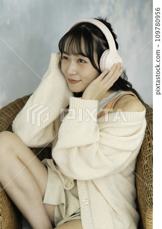 A young woman listening to music with headphones A young woman listening to music with headphones 109780956