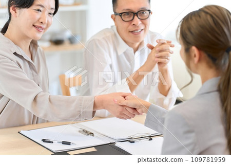 Asian woman shaking hands with insurance contract 109781959