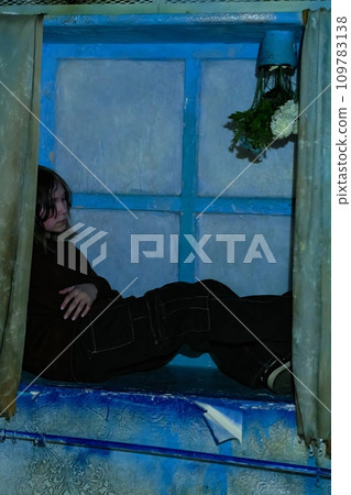 The concept of sad depression of a teenage girl. A frustrated teenage girl is sitting on a windowsill in an old sad room 109783138