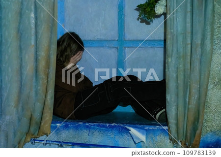 Sad girl in a state of sadness and depression on the windowsill in a state of loneliness and depression 109783139