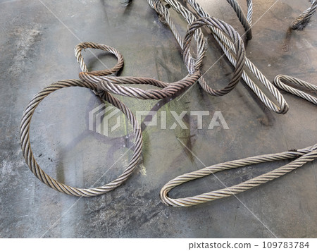 convoluted thick steel cable on steel sheet surface, close-up view convoluted thick steel cable on steel sheet surface, close-up view 109783784