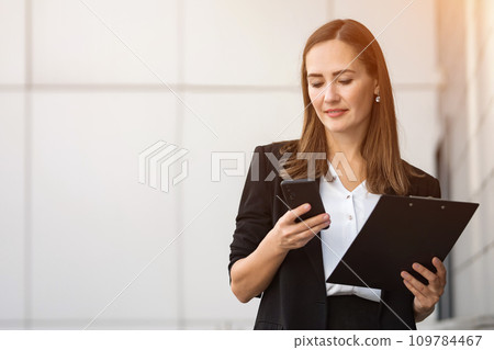 Business woman dressed in formal suit ends business call 109784467
