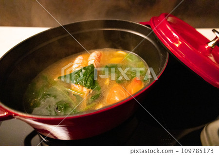 Seafood bouillabaisse, miso soup, and tomato soup being cooked in a stylish red Dutch oven pot (Chiba Prefecture) 109785173