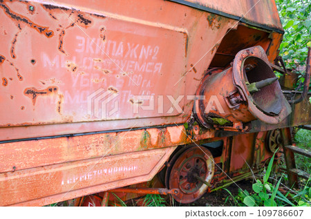 Inscription with socialist commitment on abandoned combine harvester in resettled village in Chernobyl exclusion zone, Belarus. Inscription on harvester 109786607