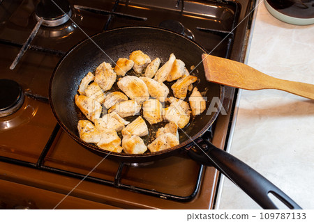 chicken breasts meat only on frying pan and wooden spatula, domestic healthy cuisine, real life situation. chicken breasts meat only on frying pan and wooden spatula, domestic healthy cuisine, real life situation. 109787133