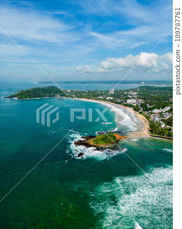 Aerial panorama of coastal landscape with serene ocean, leisure boats sailing near vibrant town. Drone shot over picturesque seaside community, holiday destination with natural beauty and tranquility. Aerial panorama of coastal landscape with serene ocean, leisure boats sailing near vibrant town. Drone shot over picturesque seaside community, holiday destination with natural beauty and tranquility. 109787761
