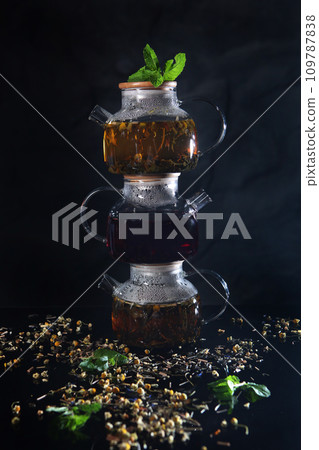 Glass teapots with tea. Teapots stand on top of each other. Healthy drink. Hot tea. Mint leaves. 109787838