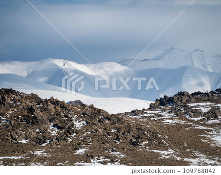 View of snowy slope on the way to the pass in the mountains. Amazing alpine view to snow mountain tops at very high altitude in sunny day. View of snowy slope on the way to the pass in the mountains. Amazing alpine view to snow mountain tops at very high altitude in sunny day. 109788042