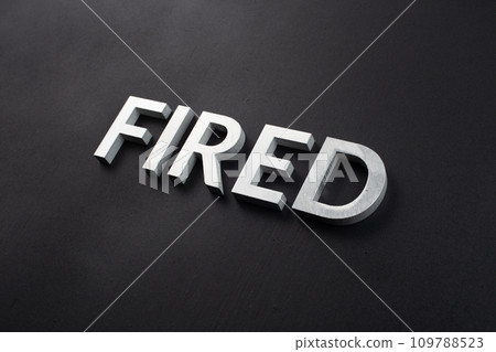 the word fired laid with silver metal letters on flat black surface 109788523