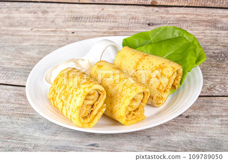 Stuffed pancakes with cream sauce Stuffed pancakes with cream sauce 109789050