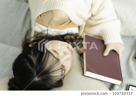 躺著拿著一本書的年輕女子 109789357
