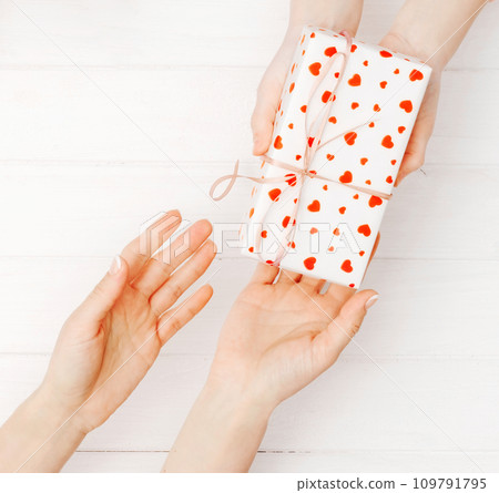 Girls hands holding lovely present box Girls hands holding lovely present box 109791795