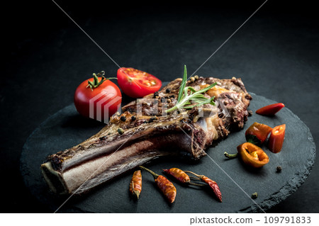 Beef steak with rosemary, chili peeper and tomatoes on slate board Beef steak with rosemary, chili peeper and tomatoes on slate board 109791833
