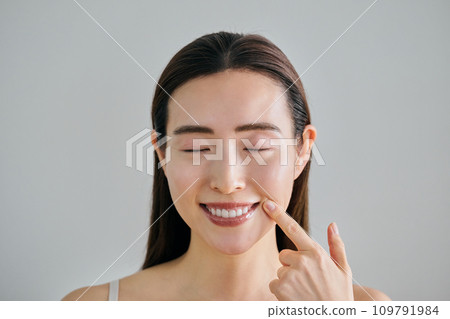 一個30多歲的女人,潔白的牙齒指向她的嘴 一個30多歲的女人,潔白的牙齒指向她的嘴 109791984