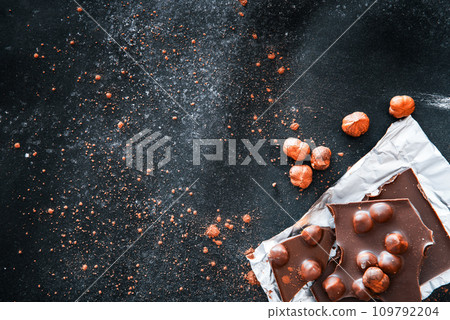 Chocolate and nuts on black table Chocolate and nuts on black table 109792204
