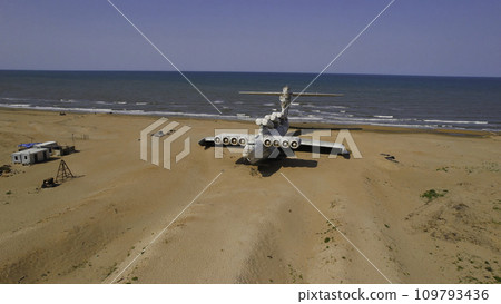 Old plane on beach. Action. Military plane landed on coast of sea many years ago. Abandoned military plane on seashore with history Old plane on beach. Action. Military plane landed on coast of sea many years ago. Abandoned military plane on seashore with history 109793436